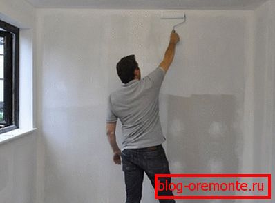 Sur la photo - application d'un apprêt sur les murs en placoplâtre Sur la photo - application d'un apprêt sur les murs en placoplâtre