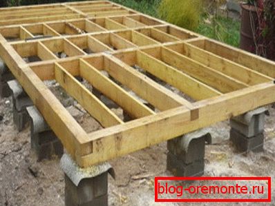 Sur la photo, la base de la colonne de support sous la maison en bois Sur la photo, la base de la colonne de support sous la maison en bois