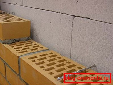 La structure du mur avec une fente et des liens sous la forme de clous en spirale. La structure du mur avec une fente et des liens sous la forme de clous en spirale.