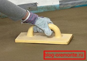 Cimenter le sol en béton manuellement avec une râpe en plastique Cimenter le sol en béton manuellement avec une râpe en plastique
